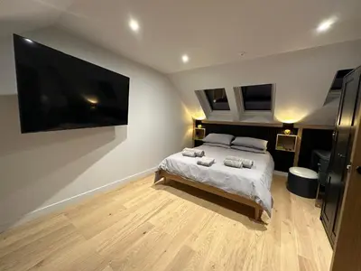 a bedroom with a bed and a large tv at Laurieston Penthouse in Grahamston