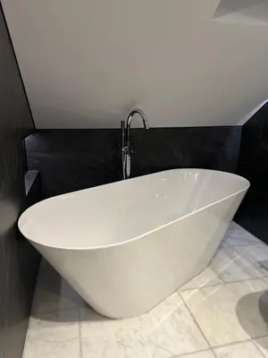 a white bath tub in a bathroom with a faucet at Laurieston Penthouse in Grahamston