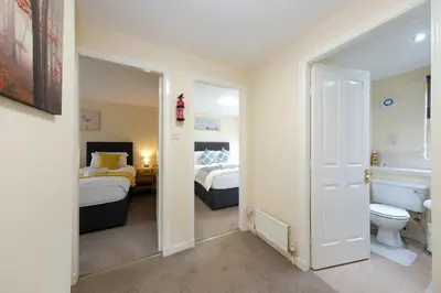 a bedroom with two beds and a bathroom with a toilet at Pure Apartments Commuter- Dunfermline South in Fife