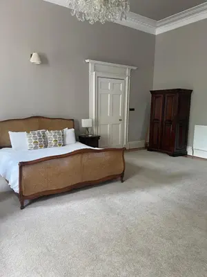 a bedroom with a large bed and a chandelier at Private Guest Suite in Georgian Townhouse in City Centre in Edinburgh