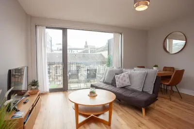 a living room with a couch and a table at 1 Bedroom Flat in the Heart of Merchant City in Glasgow