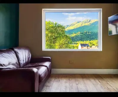 a living room with a couch and a large window at Kinlochleven Holiday Home in Kinlochleven