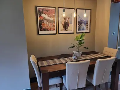 a dining room table with chairs and pictures on the wall at Kinlochleven Holiday Home in Kinlochleven