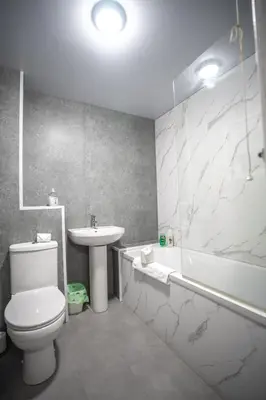 a bathroom with a toilet and a sink and a bath tub at Livi House in Livingston