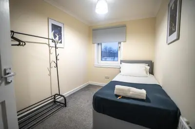 a small bedroom with a bed and a window at Livi House in Livingston