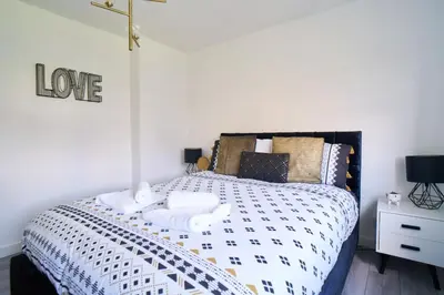 a bedroom with a bed with towels on it at Woodside Apartment in Coatbridge
