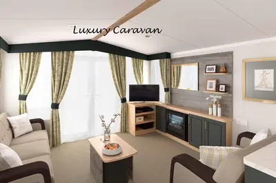 a living room with a couch and a tv at Inverbeg Holiday Park in Luss