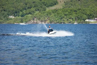 a man on a jet ski in a lake at Inverbeg Holiday Park in Luss