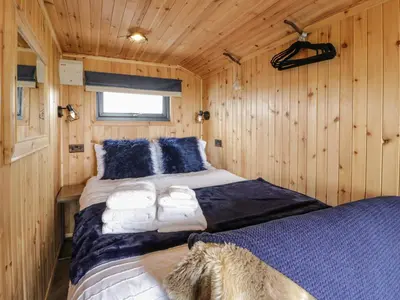 a bedroom with a bed in a wooden cabin at Greenacres Carriage in Maybole