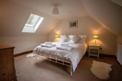 a bedroom with a bed with towels on it at Kennels Cottage in Killin