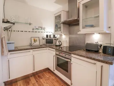 a kitchen with white cabinets and stainless steel appliances at Silverbells in Millport