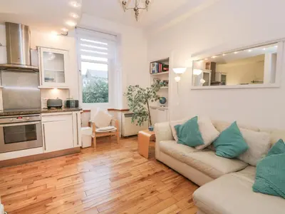 a living room with a couch and a kitchen at Silverbells in Millport