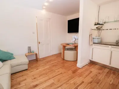 a living room with a couch and a wooden floor at Silverbells in Millport