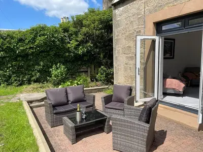 a patio with two wicker chairs and a table at Fantastic home in Brightons, Falkirk. in Polmont