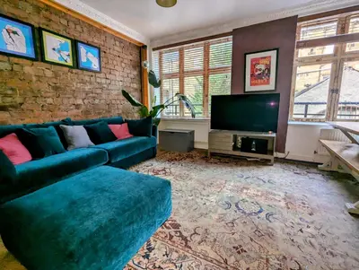 a living room with a blue couch and a tv at One The Mews in Glasgow