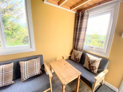 a living room with a couch and a table at Blair Tiny House with Private Hot Tub - Fife - Loch Leven - Lomond Hills in Dunfermline