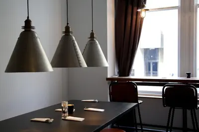 a dining room with a table and three lights at The Z Hotel Glasgow in Glasgow