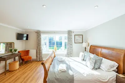 a bedroom with a bed and a desk and a window at Sparrowhawk Cottage with Hot Tub in Newton Stewart
