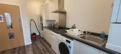 a kitchen with a sink and a washing machine at The Arches The Wee Yin in Stirling