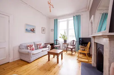 a living room with a couch and a fireplace at JOIVY Splendid Apartment near Haymarket in Edinburgh