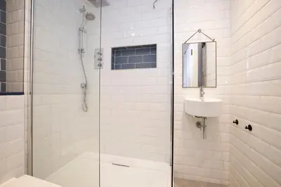 a bathroom with a shower and a toilet and a sink at JOIVY Splendid Apartment near Haymarket in Edinburgh