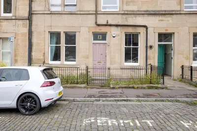 a white car parked in front of a building at JOIVY Splendid Apartment near Haymarket in Edinburgh
