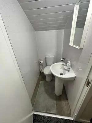 a white bathroom with a toilet and a sink at Rangers GuestHouse in Glasgow