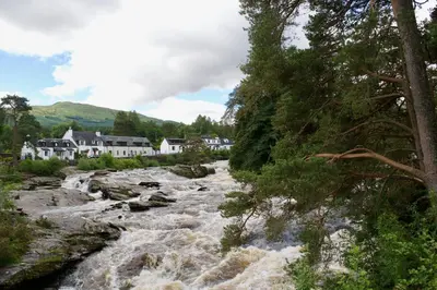 a river with rapids in front of houses at Tigh Muileann in Killin