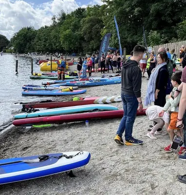 a group of people standing next to kayaks on the water at Heather Cottage Luss in Luss