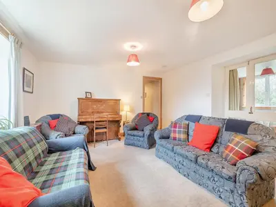 a living room with two couches and a piano at Brondeg Lodge in Crarae