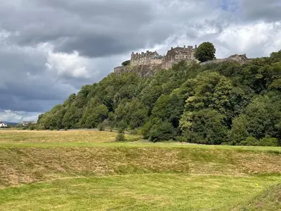 a castle on top of a hill with a field at Castle Brae Apartment in Stirling