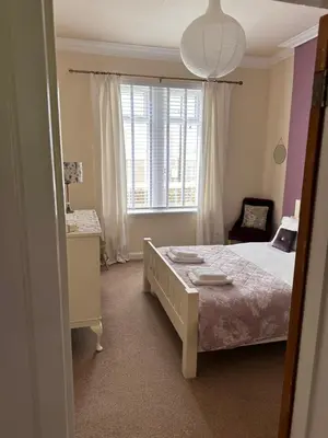 a bedroom with a bed and a window at Castle Brae Apartment in Stirling
