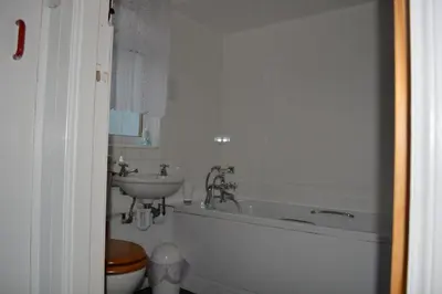 a bathroom with a sink and a tub and a toilet at Seal Cottage in Portnahaven
