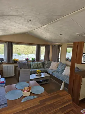 a living room with a couch and a table at Loch Earn Holiday Home in Saint Fillans