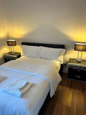 a bedroom with a large white bed with two lamps at Royal Apartments Edinburgh in Edinburgh