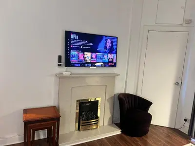 a living room with a tv above a fireplace at Royal Apartments Edinburgh in Edinburgh