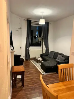 a living room with a black couch and a table at Royal Apartments Edinburgh in Edinburgh