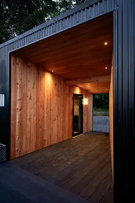 a wooden garage with a wooden deck at The Black Cabin Oban in Oban