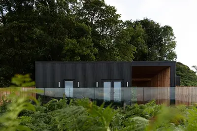 a black house with a glass facade at The Black Cabin Oban in Oban