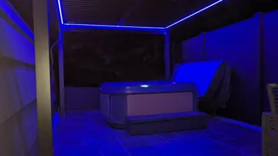 a dark room with a blue light and a tub at Beach House Pods in Dunoon