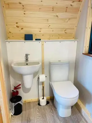 a bathroom with a toilet and a sink at Beach House Pods in Dunoon