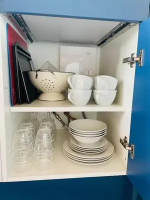 a cupboard filled with bowls and plates and dishes at Beach House Pods in Dunoon