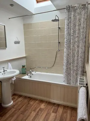 a bathroom with a bath tub and a sink at The Haven in Saint Fillans