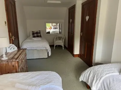 a bedroom with two beds and a mirror at The Haven in Saint Fillans