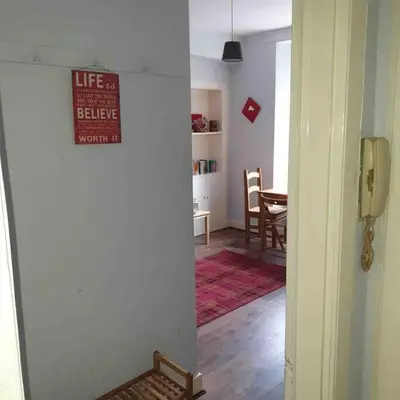 a hallway with a living room with a sign on the wall at Caledonian - Charming Central 1 Bed Flat in Edinburgh