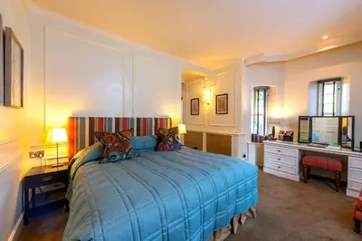 a bedroom with a blue bed and a desk at Isle of Eriska Hotel Spa & Island in Benderloch