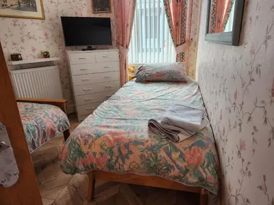 a small bedroom with two beds and a tv at Apartment - Largs - Sleeps 4 - Pet Friendly in Largs