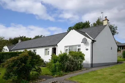 a white house with a black roof at Ardview Cottage in Oban