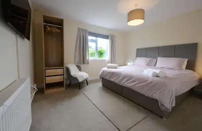a bedroom with a large bed and a window at Ardview Cottage in Oban