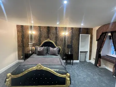 a bedroom with a large bed with a gold frame at Castle Gogar Cottage in Edinburgh